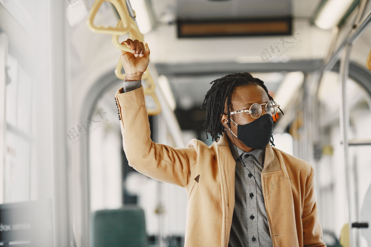 男人非裔美国人坐在城市巴士上穿棕色外套的家伙电晕病毒概念外套旅游非洲