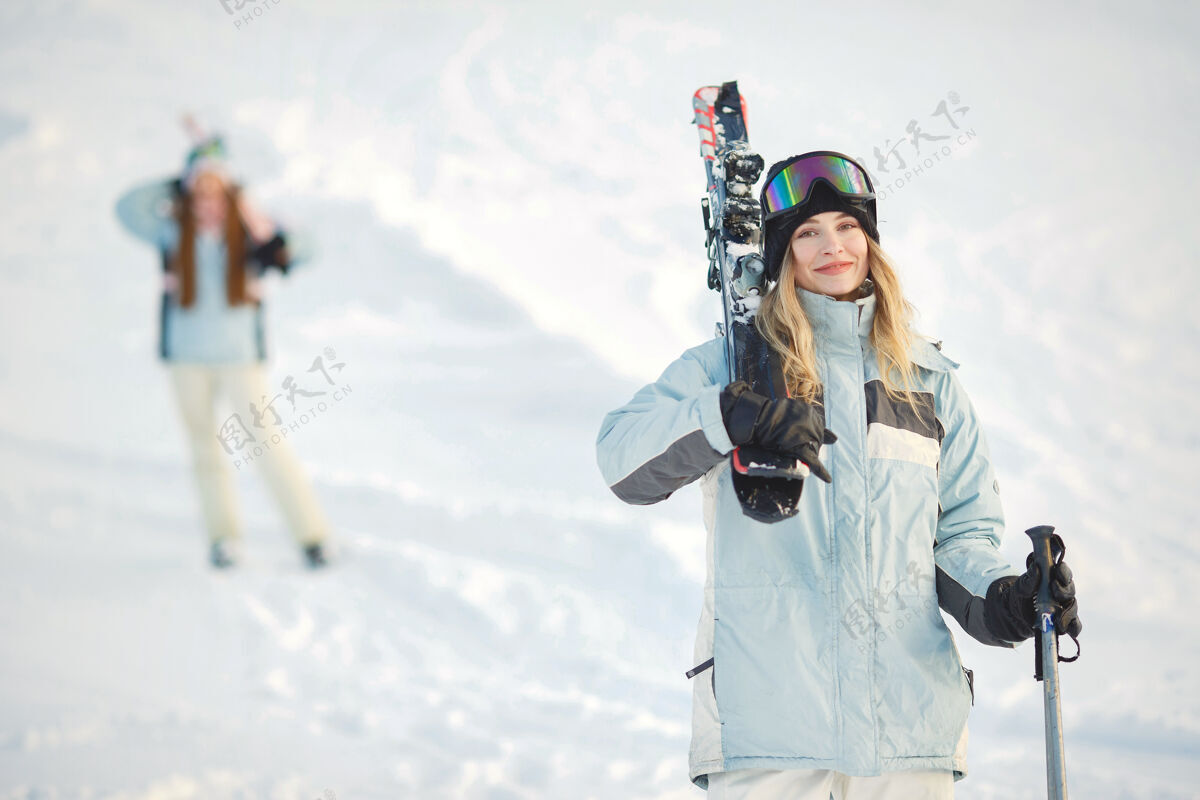 红色在雪山的背景下 滑雪者在山坡上摆姿势运动女人冷