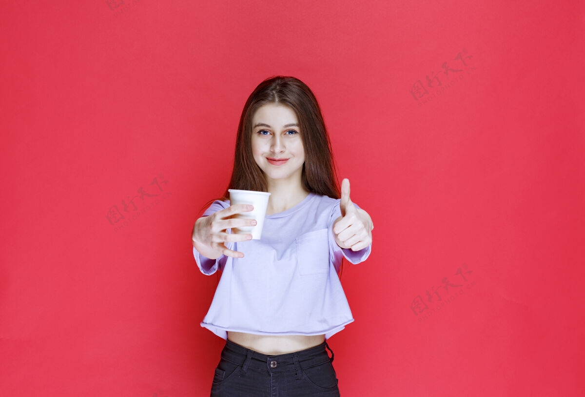纸杯年轻女子手持白色一次性水杯 露出满意的表情休闲积极口味
