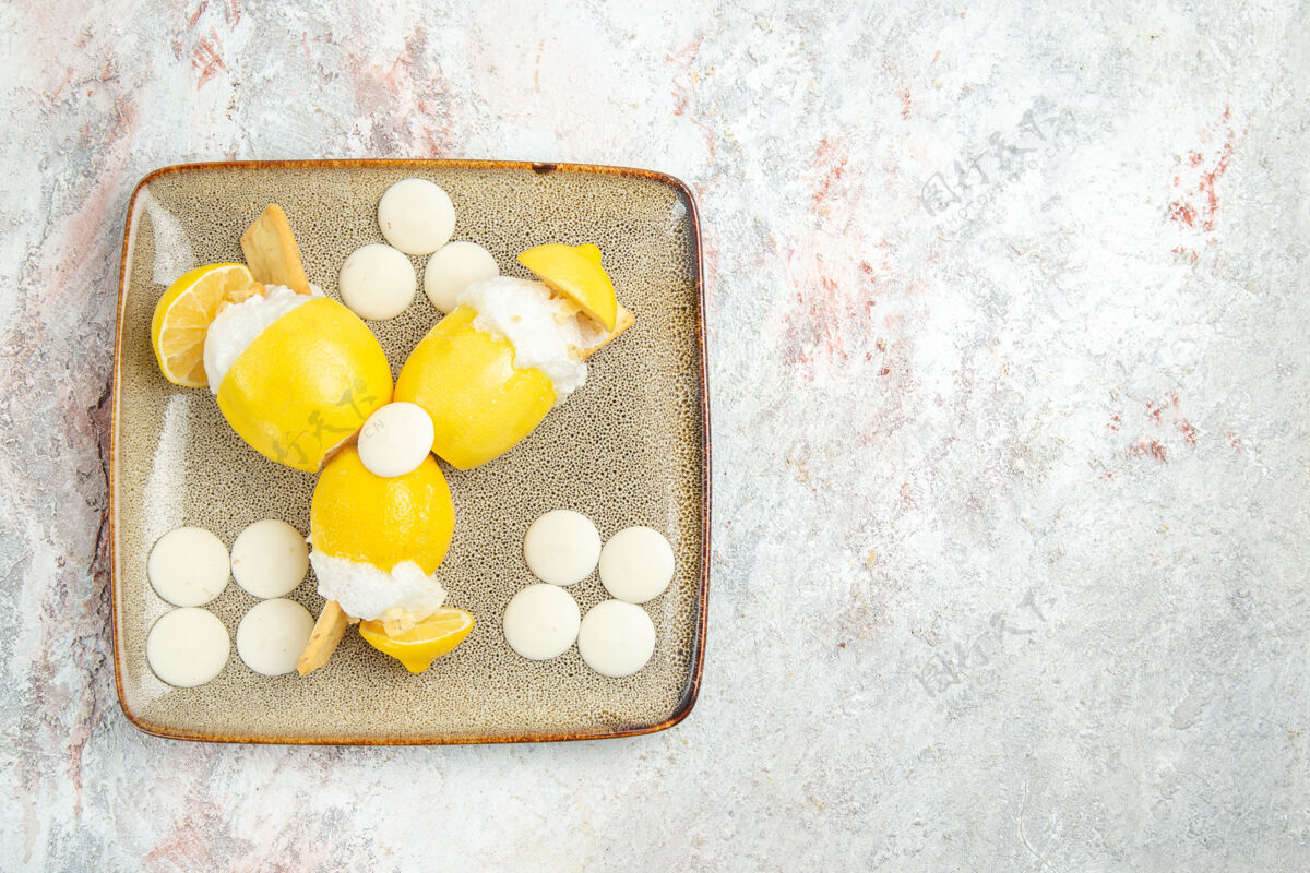 糖果俯瞰冰柠檬和白糖果在白色桌子上水果饮料鸡尾酒果汁图钉柠檬健康