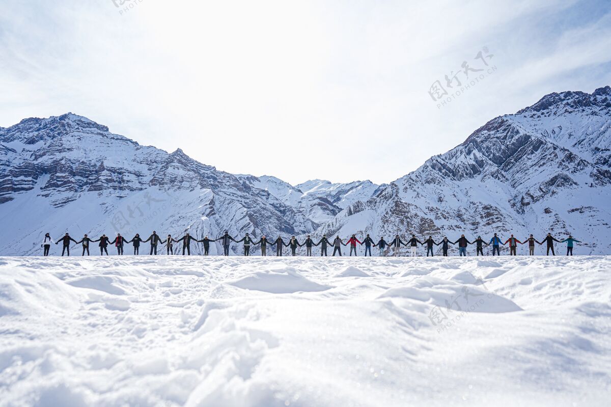 风景人们手牵着手 象征着冬天与山峦的和平季节天空雪