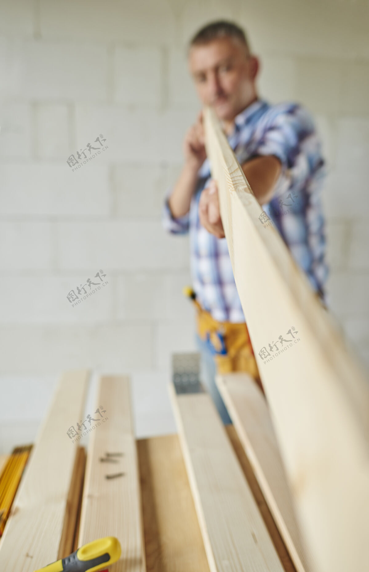 触摸拿木板的高级木匠测量设计离焦