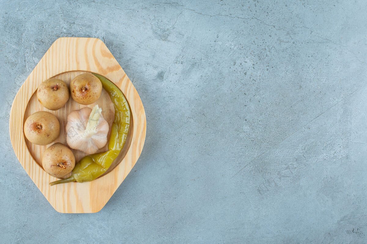 美味自制发酵蔬菜放在大理石表面的木盘上可口苹果大蒜