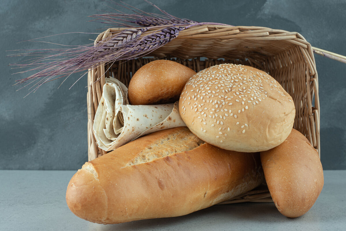 石头篮子里有各种各样的面包 石头表面有小麦谷类什锦面包