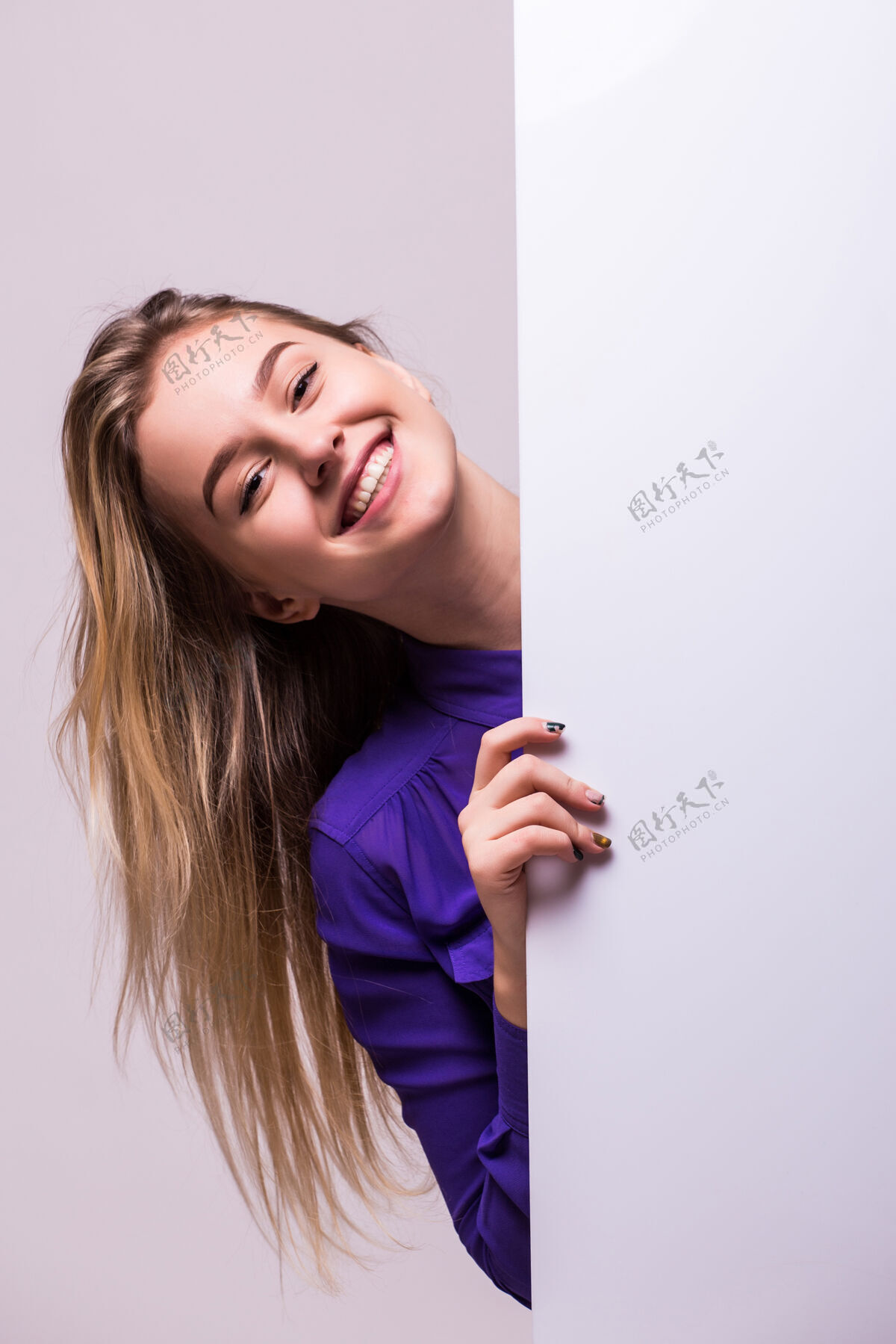 肖像美丽的女人拿着一块空白的广告牌孤立在白色的墙上女人空白微笑