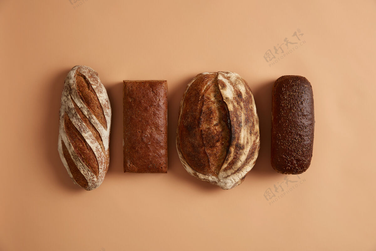 早餐主食和健康营养的概念四种面包隔离在棕色背景上小麦 黑麦 富含维生素和矿物质 有机面粉制成的拼写面包 对健康有好处酸面团平衡新鲜