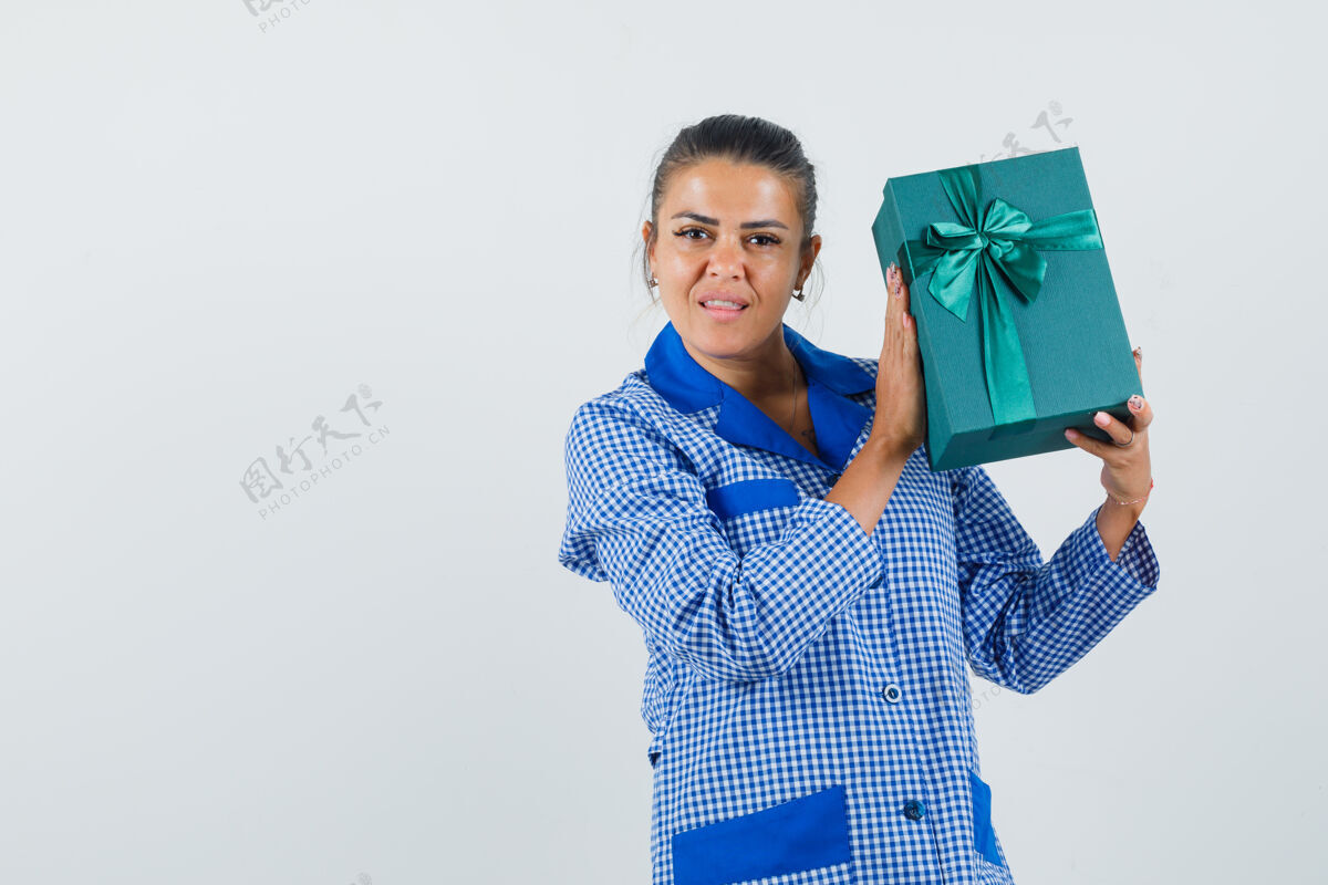 黑发年轻女子拿着礼品盒 穿着蓝色方格睡衣衬衫 看起来很漂亮 正前方的景色成人魅力人
