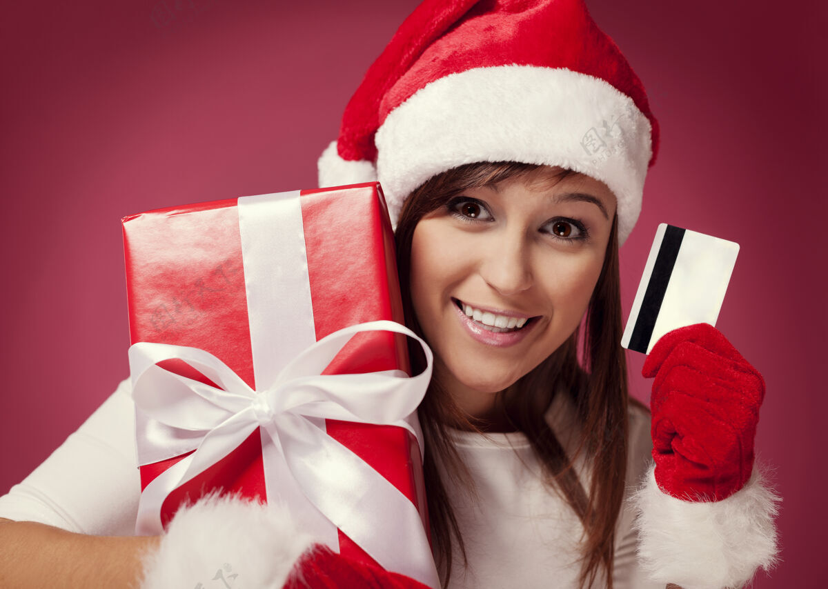 女人带着红色礼品盒和信用卡的圣诞老人圣诞老人可爱圣诞帽