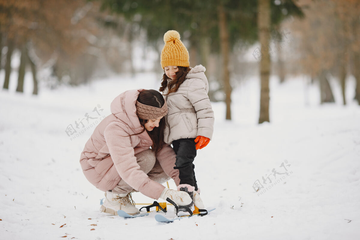 健康妈妈帮女儿把她的天空休闲假期下雪