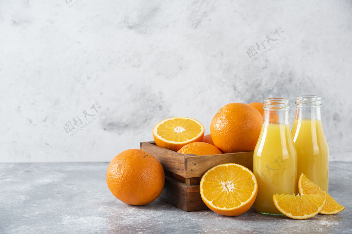 新鲜石桌上放着一个木制的旧盒子 里面装满了多汁的橙子美味水果橙子