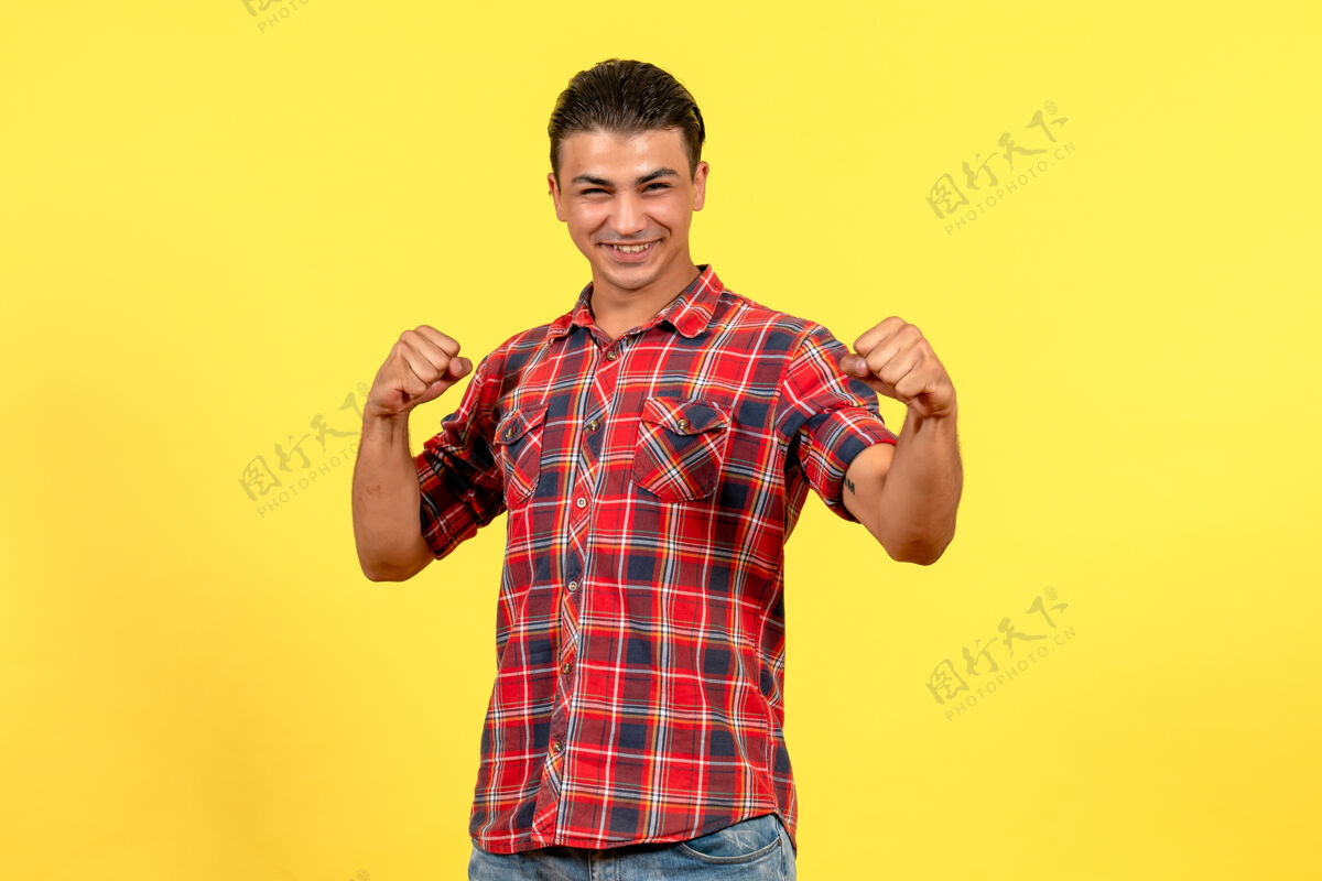 人物正面图身着鲜艳衬衫的年轻男性在黄色背景上微笑的男模明亮肖像男人