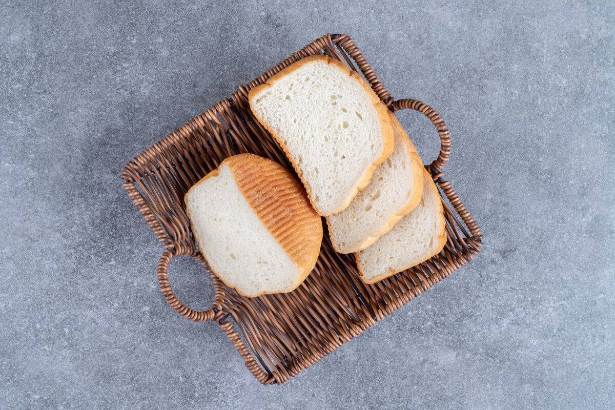 切片柳条篮子的切片白面包放在石头桌上切脆面包房