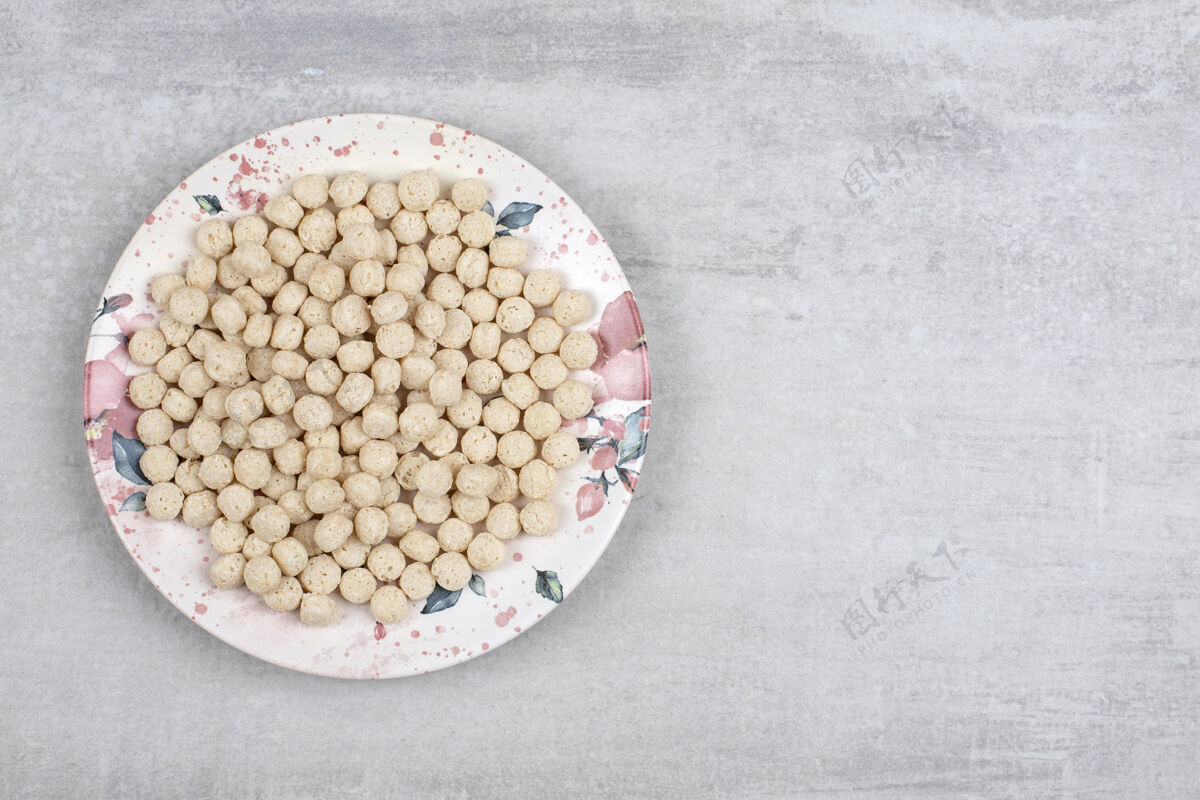 谷类食品石头桌上摆满了玉米粒球的白色盘子干玉米自然