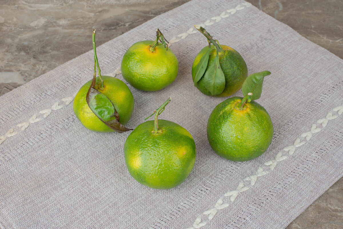 叶子一堆新鲜的橘子放在灰色的桌布上柑橘有机天然