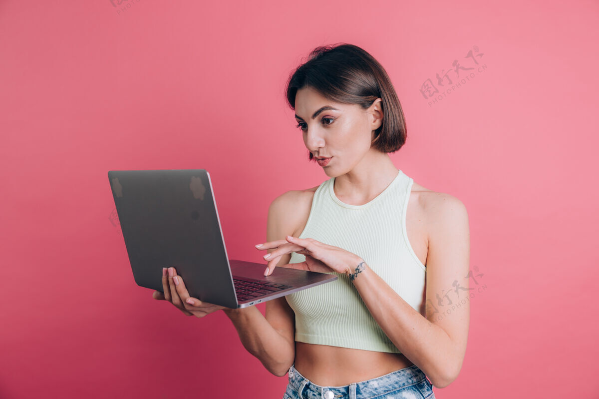 自我粉色背景的女人拿着笔记本电脑笑得很开心女性肖像女孩