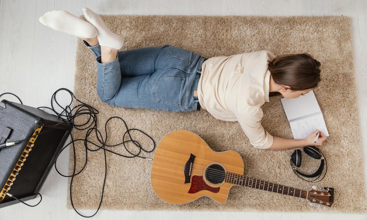 室内平躺的女音乐家在家里用耳机和原声吉他写歌艺术家音乐家室内
