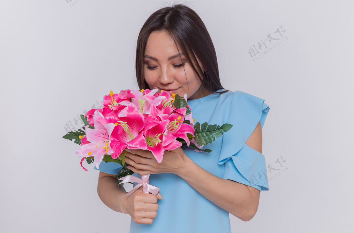 欢呼站在白色的墙上 一位亚洲妇女手持花束 神情愉快地庆祝国际妇女节花束快乐举办