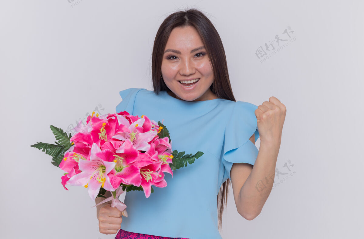 女人亚洲妇女手持花束 神情欢快 握紧拳头 站在白色的墙上庆祝国际妇女节国际欢呼站立