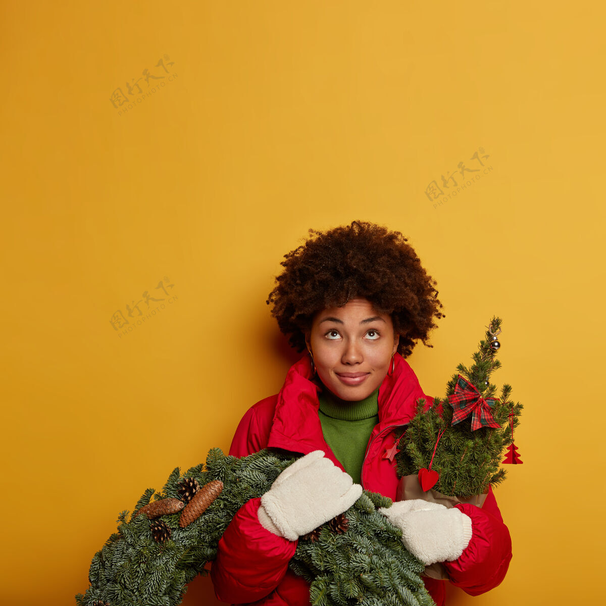 传统年轻漂亮的女人拿着圣诞装饰品圆锥体花环携带