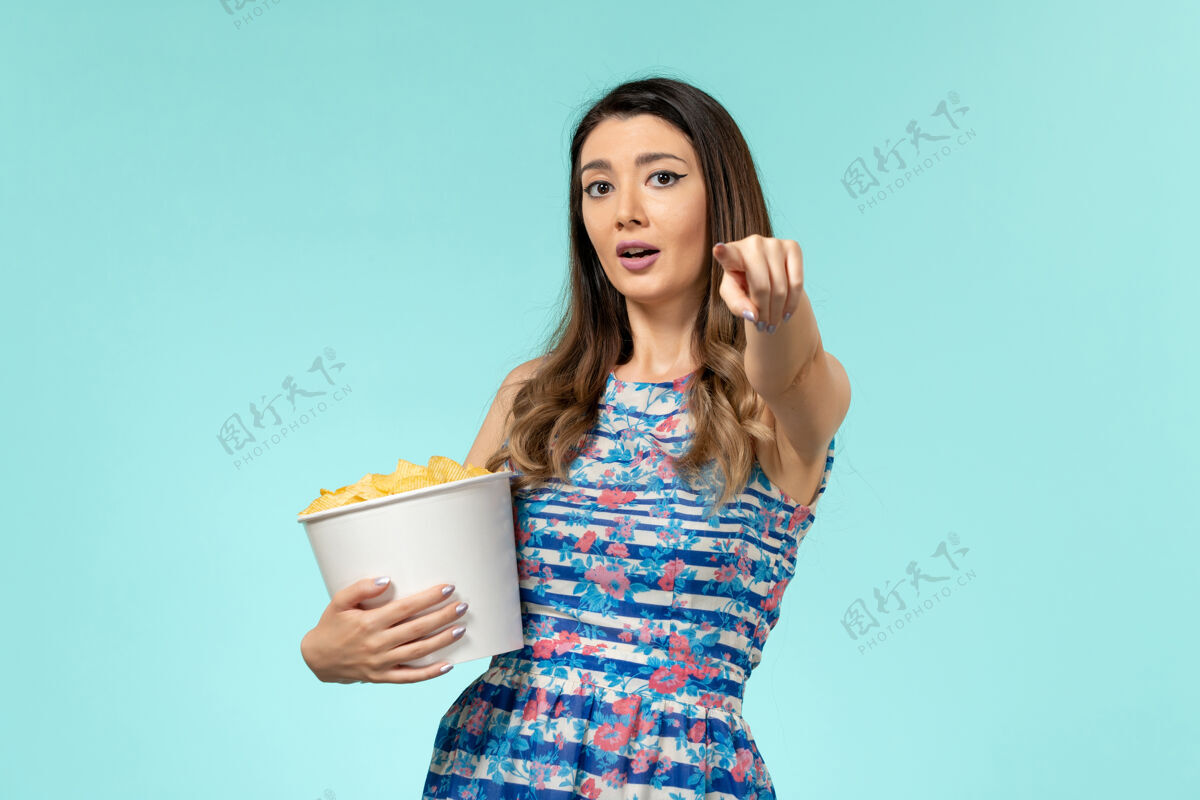 电影正面图年轻的女性拿着篮子和筹码在蓝色的水面上看电影电影院抱着女士