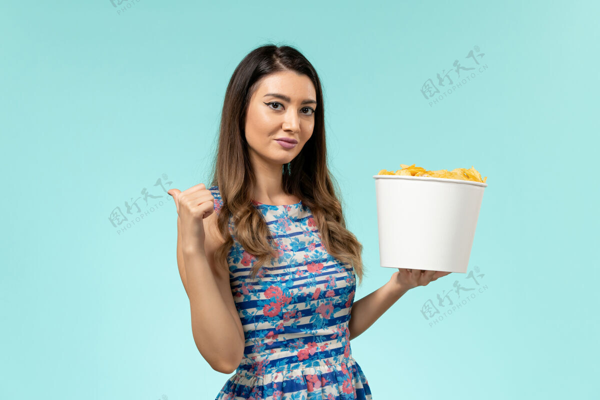 篮子正面图：蓝色桌子上拿着薯片的年轻女性篮子漂亮性感电影