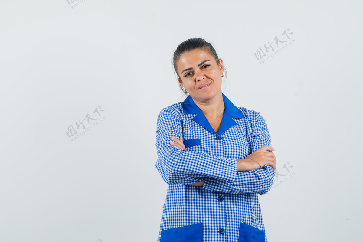 成人年轻女子双臂交叉站在蓝色格子睡衣衬衫 看起来很漂亮前视图自然健康站立