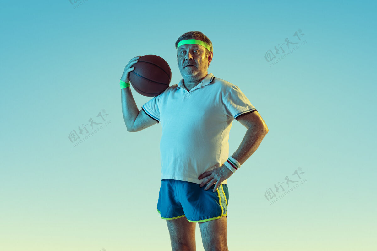 球拍资深男子在霓虹灯下的斜坡墙上打篮球发球健康教练