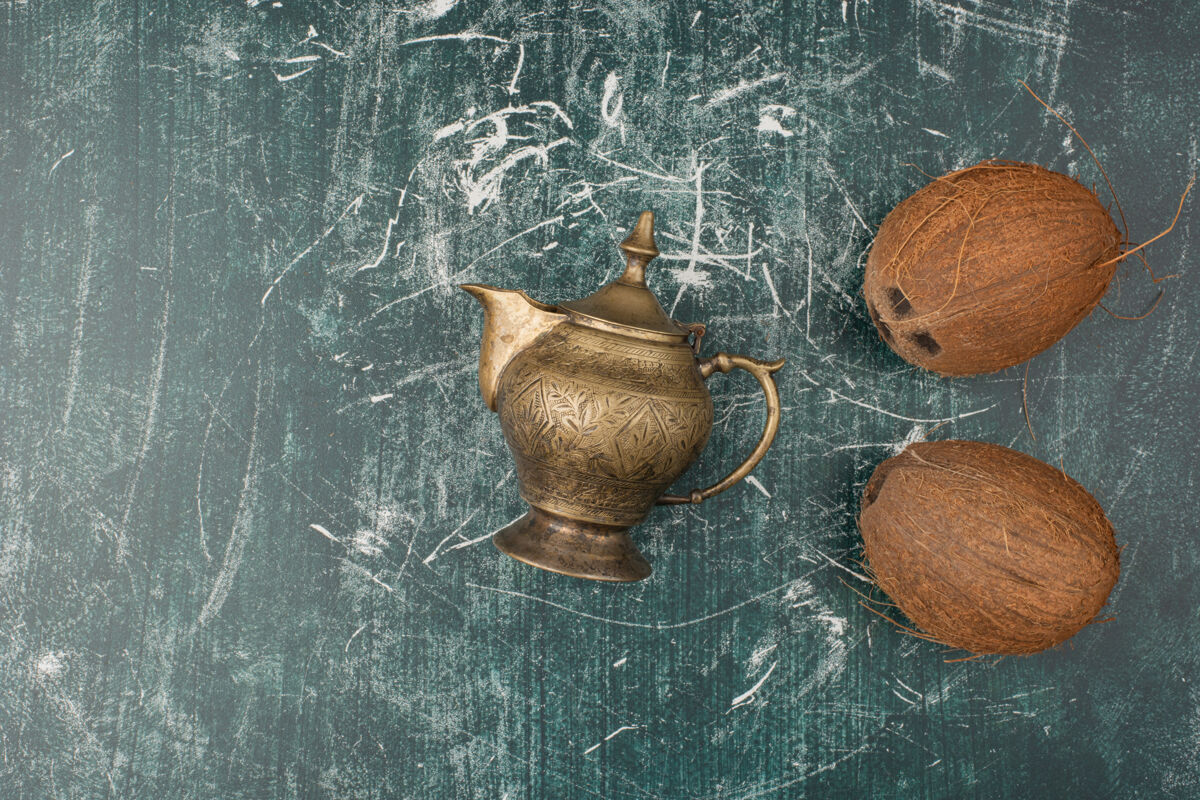 水果两个完整的椰子和茶壶在大理石表面椰子茶壶经典