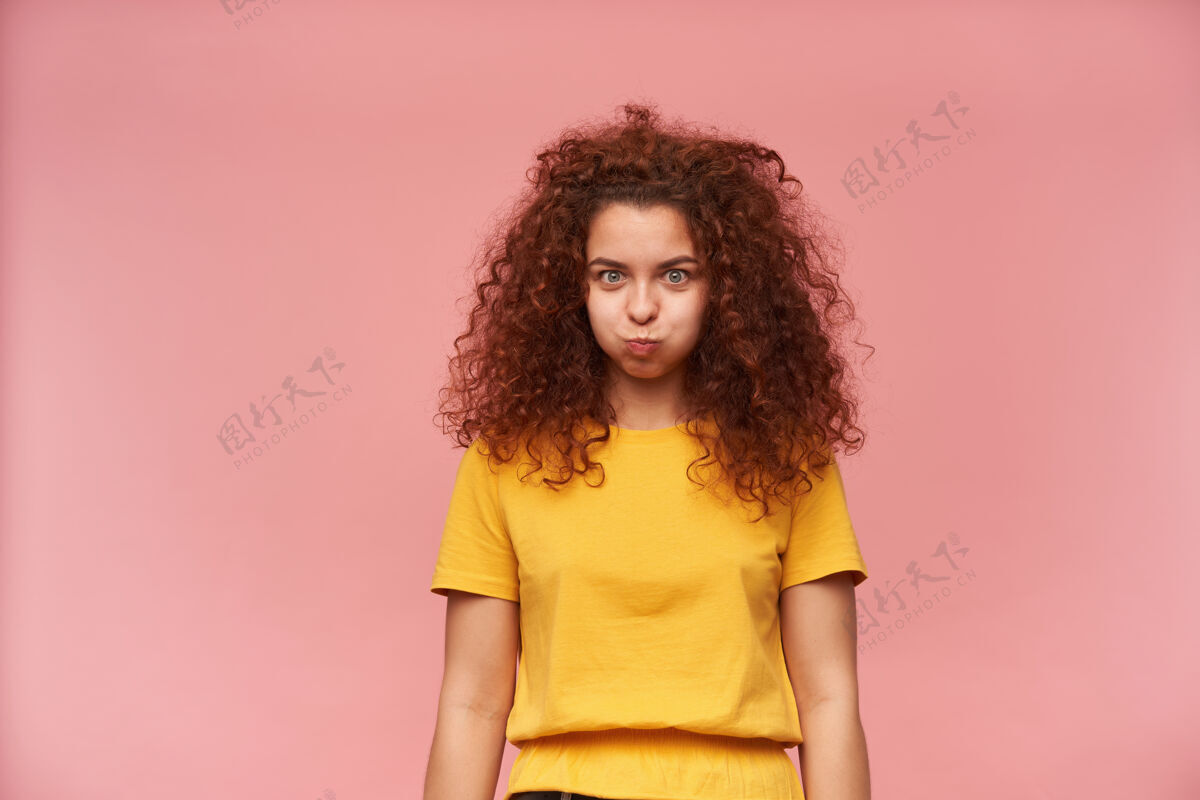 服装十几岁的女孩 滑稽的女人 姜黄色卷发 穿着黄色t恤有趣镜头姜