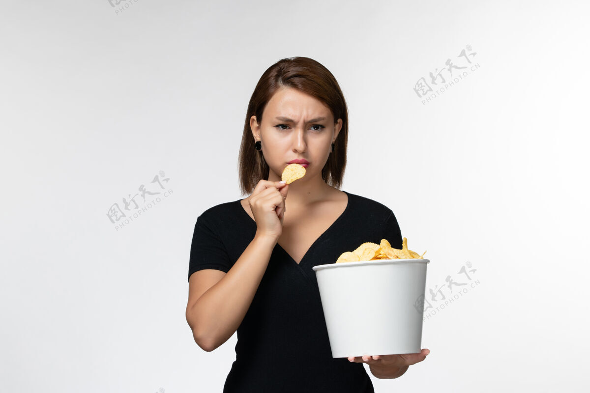 前面正面图：白色书桌上的年轻女性拿着土豆片篮子土豆剧院电影