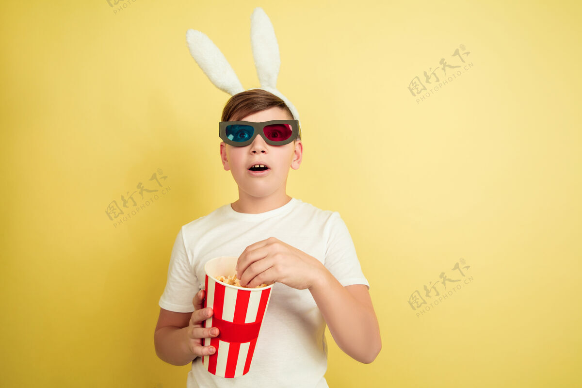 模型在黄色的墙上像复活节兔子一样的男孩青少年帅气耳朵