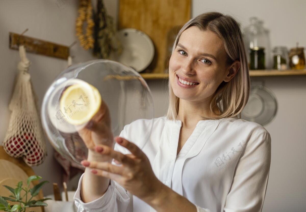 女士中镜头笑脸女人用柠檬清洗清洁生态生活室内