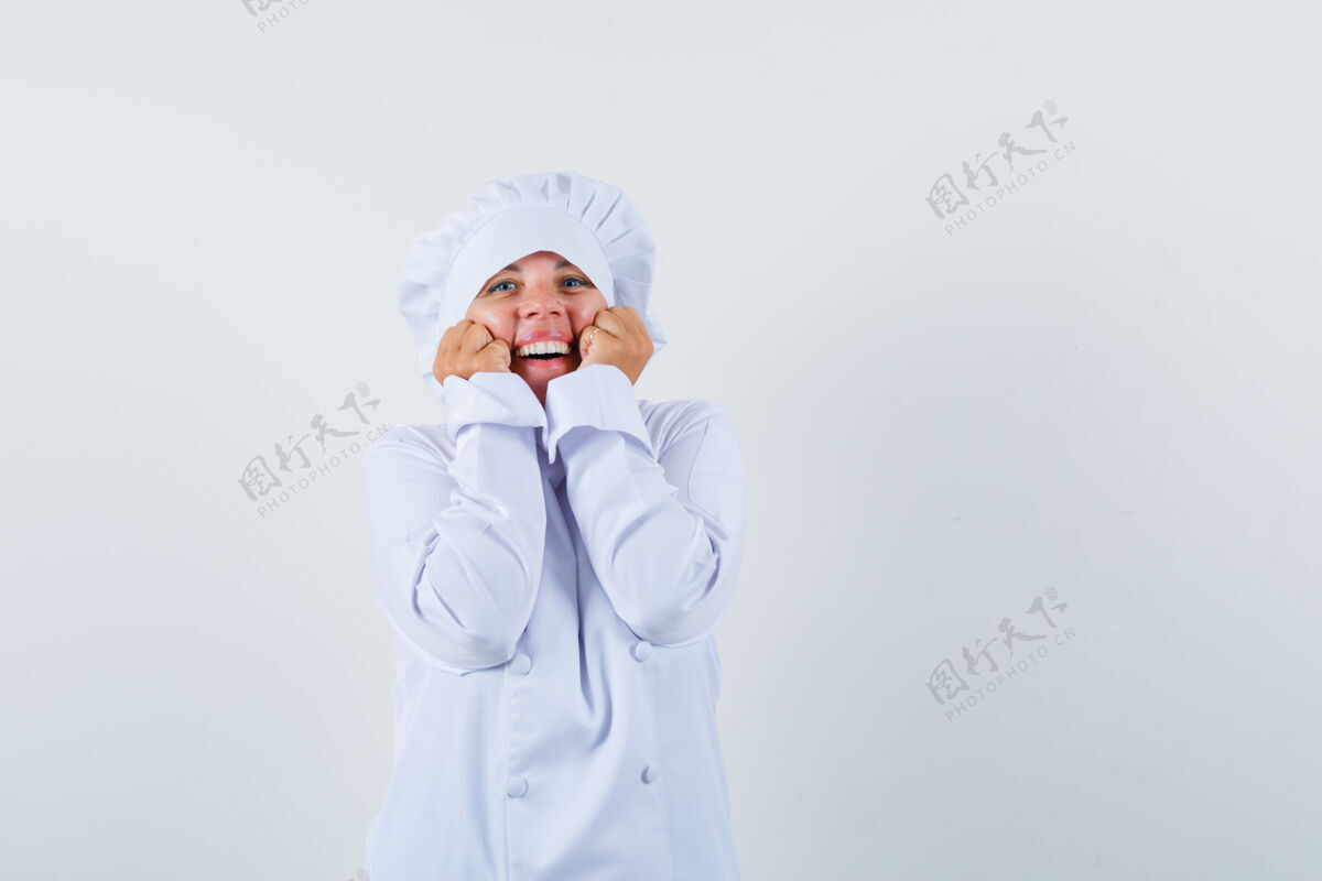 握紧金发女人手托下巴 紧握拳头穿着白色厨师制服 看起来很漂亮制服清洁肖像
