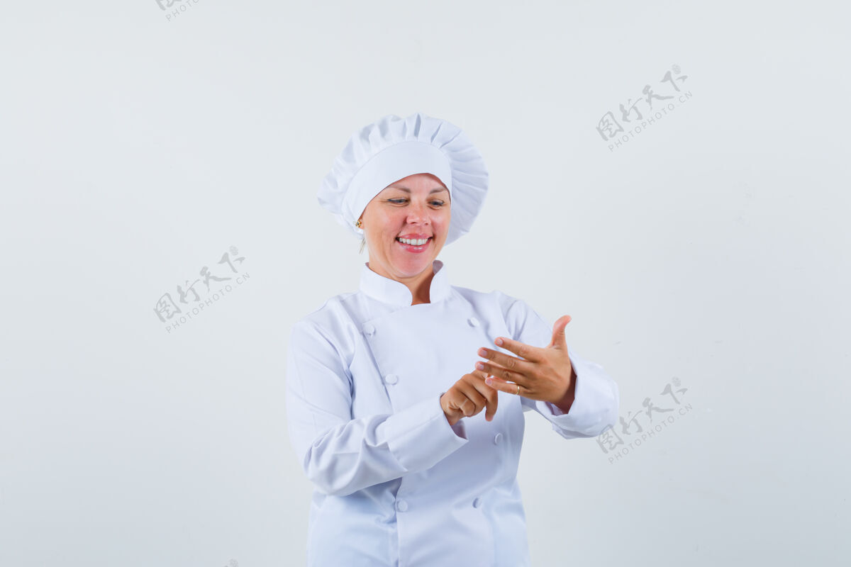 模型一个穿着白色制服的女厨师用手指数着东西 看上去很高兴脸魅力欢乐