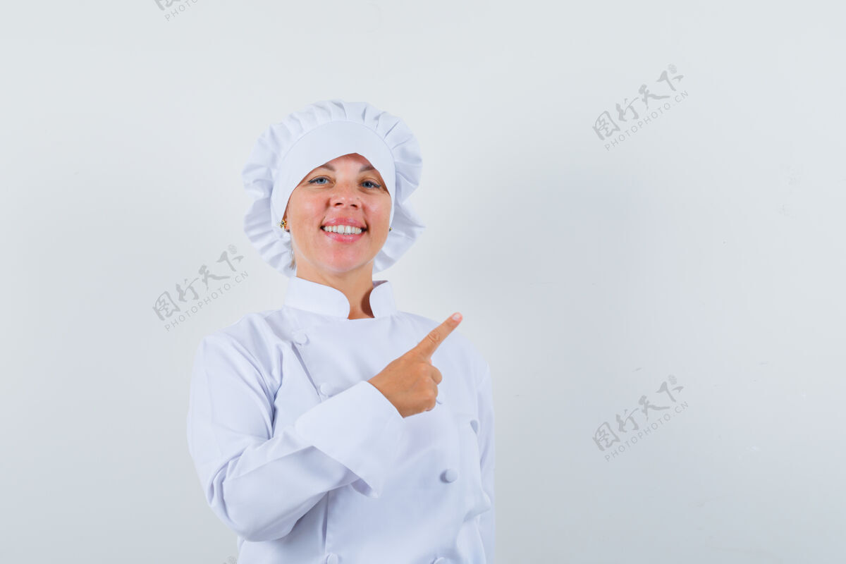 时尚身着白色制服的女厨师指着右上角 看上去很自信角落模型女人