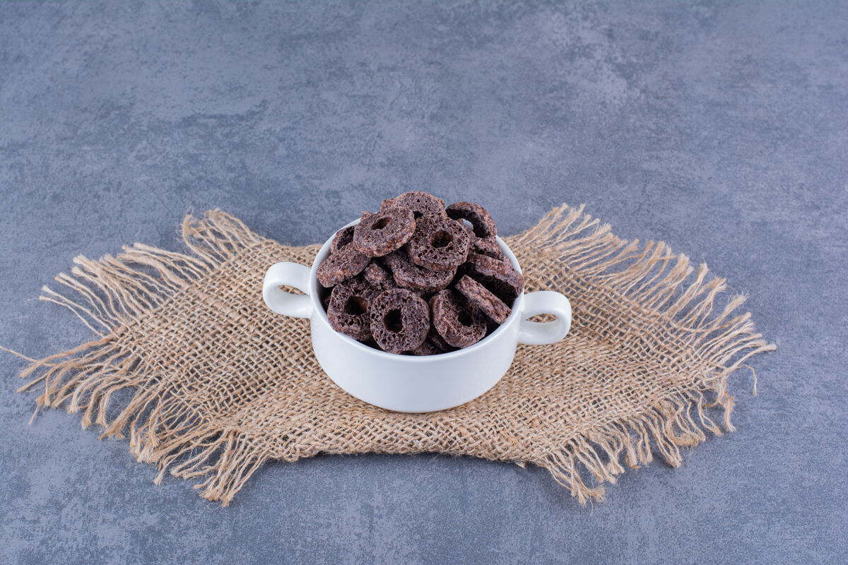 燕麦健康早餐 巧克力玉米圈放在石头盘子里小吃维生素菜