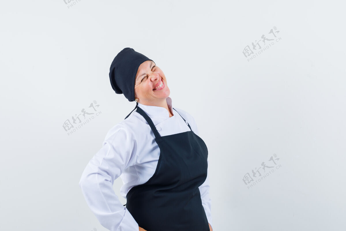 烹饪金发女人把手放在腰上 穿着黑色厨师服微笑着 看起来很漂亮亚洲人皮肤放