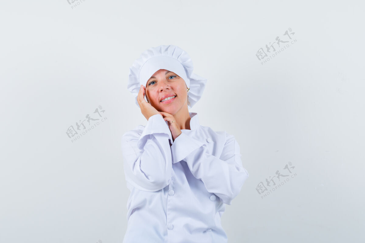 肖像一位身穿白色制服的女厨师抚摸着脸颊上的皮肤 看上去很优雅可爱厨师模特