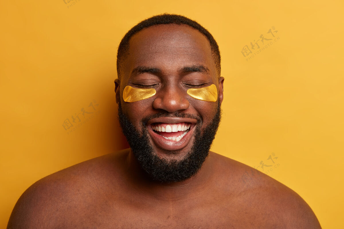 看喜出望外的黑皮肤男模头戴金色眼罩 做美容卫生程序清新美容头部
