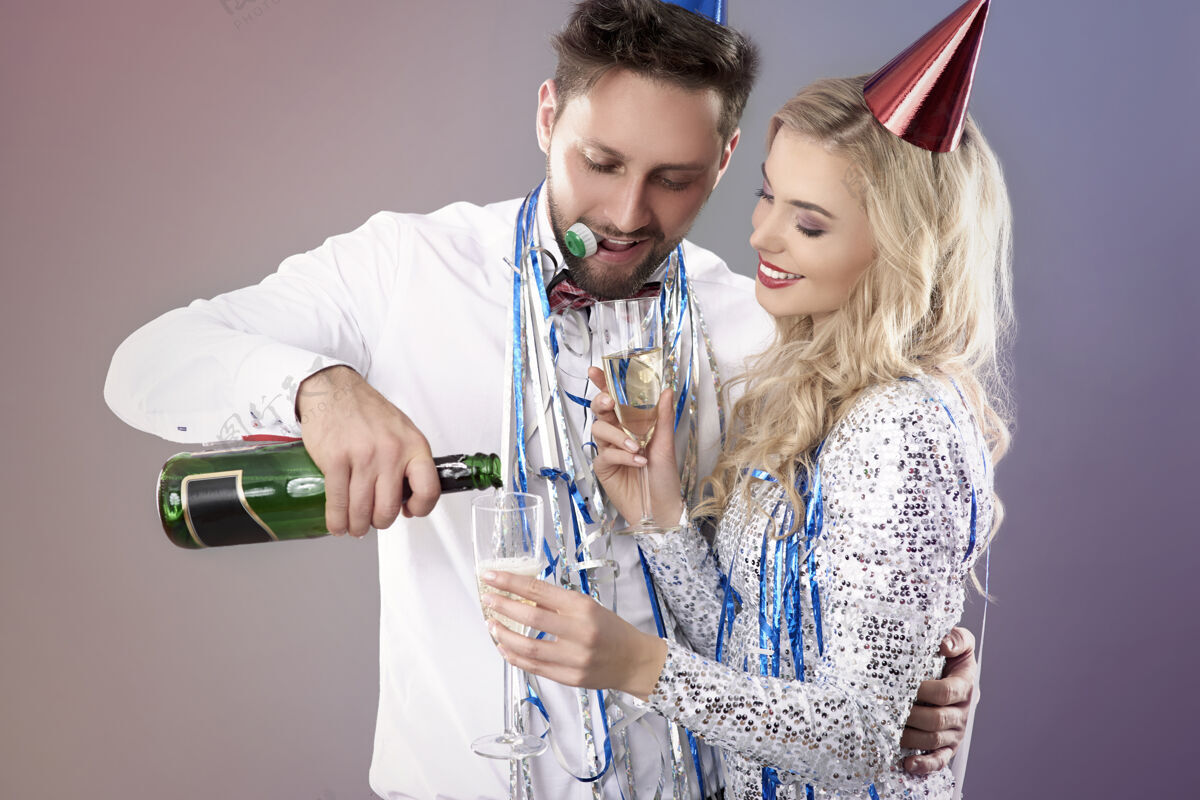 喝酒一对年轻夫妇在庆祝新年前夜新年庆祝祝酒词拥抱