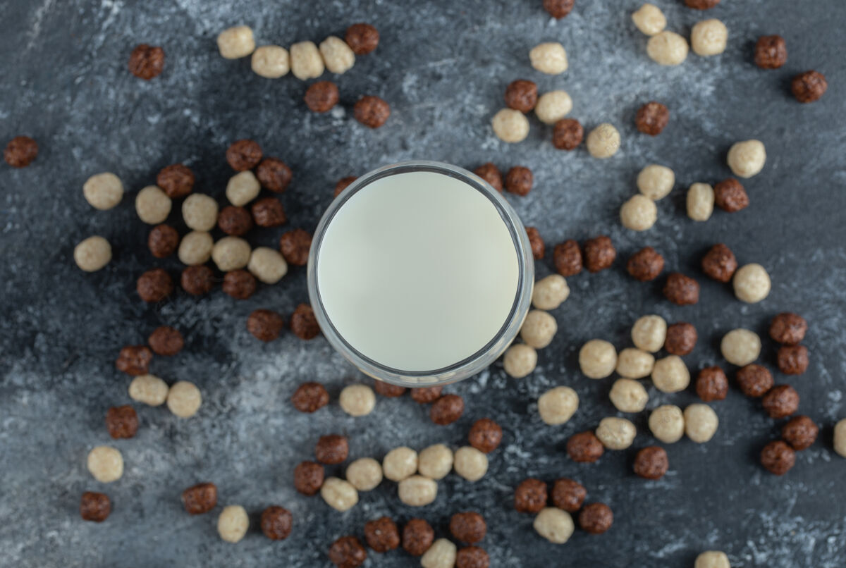 谷类一堆麦片球散落在一杯牛奶周围脆小麦蛋白质