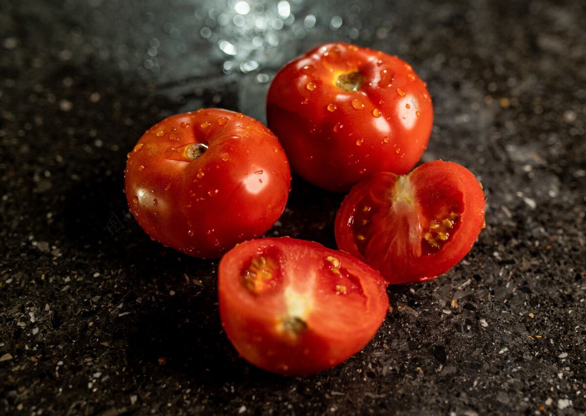 维生素特写新鲜成熟的西红柿水滴在一个黑色花岗岩厨房台面清洁有机收获