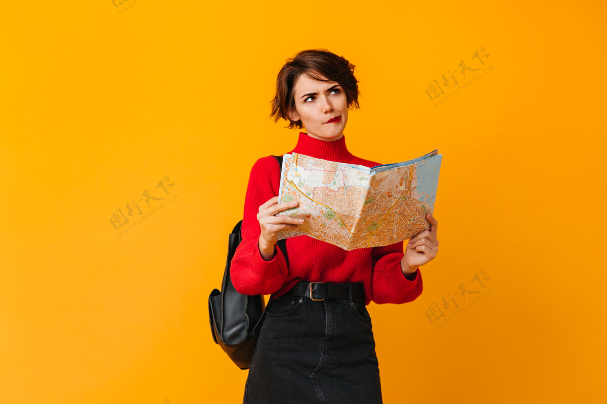 路线沉思的女人 带着地图望着别处人旅游年轻