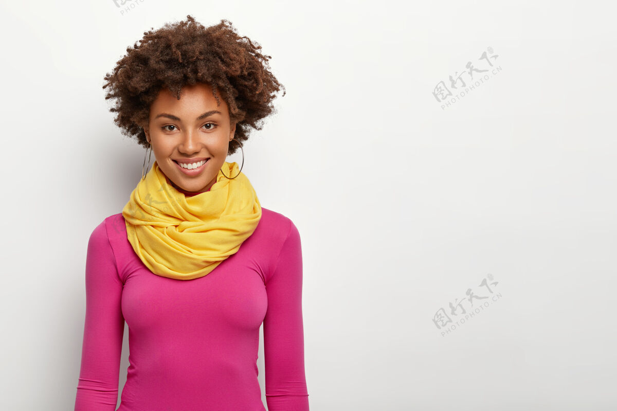 耳环时髦的卷发女人 清爽的发型 戴着黄色的围巾和粉色的马球衫 笑容灿烂肖像头发时尚