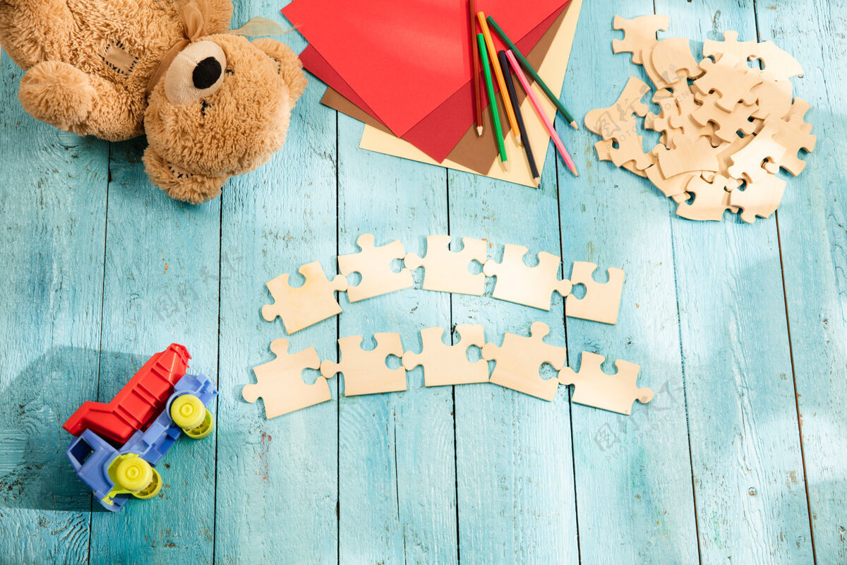 新的拼图 蜡笔 玩具卡车 泰迪熊和木头桌子上的纸童年和教育的概念学校碎片计划