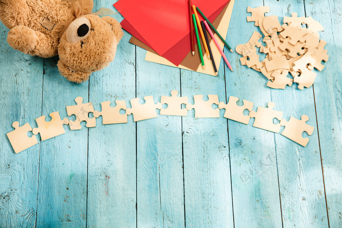 文字拼图 蜡笔 玩具熊和一张木桌上的纸童年和教育的概念爱拼图平板