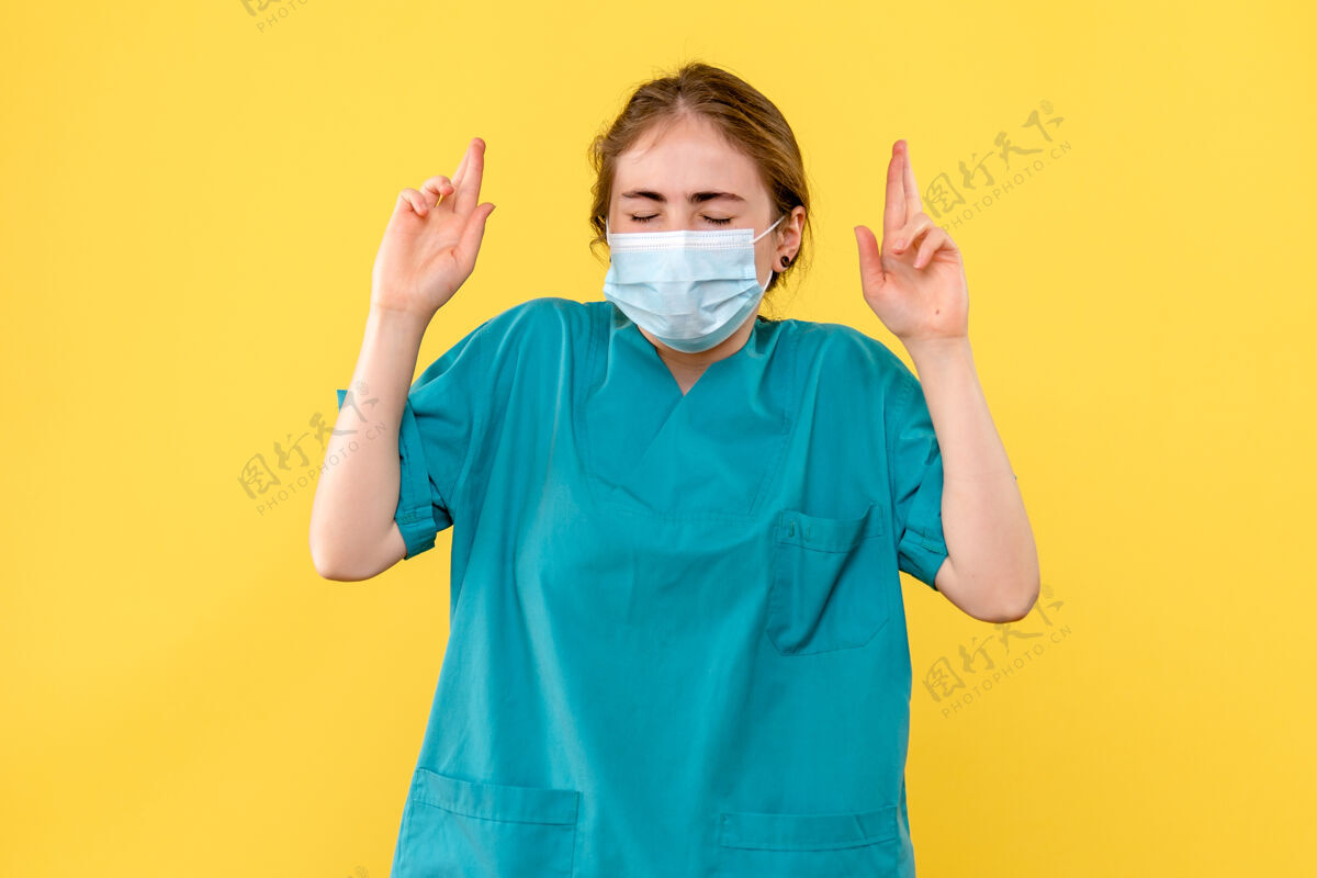 成人前视图女医生希望在黄色背景上戴口罩健康医院共患大流行实验室外套人面具