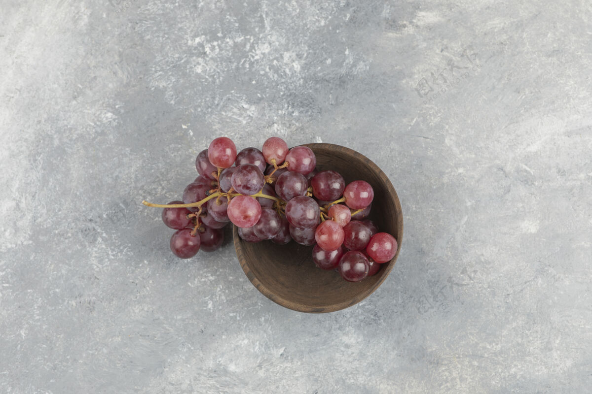 甜味在大理石表面放上一碗新鲜的红葡萄美味有机健康