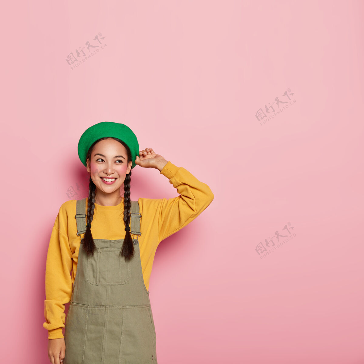 姿势漂亮的中国女人 脸上涂着胭脂 头上戴着时尚的贝雷帽 穿着运动衫和萨拉凡面部贝雷帽高兴