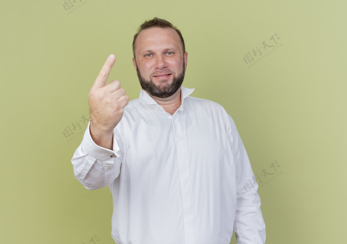 手指留着胡子的男人穿着白衬衫 微笑着伸出食指 或是站在光墙上的头号人物目录显示微笑